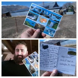 man smiling while holding his postcard from Iceland