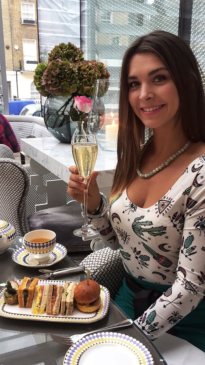 woman holding champagne at high tea