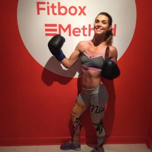 woman holding boxing gloves in front of FitBox method