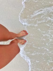 woman's feet in the water of baby beach aruba