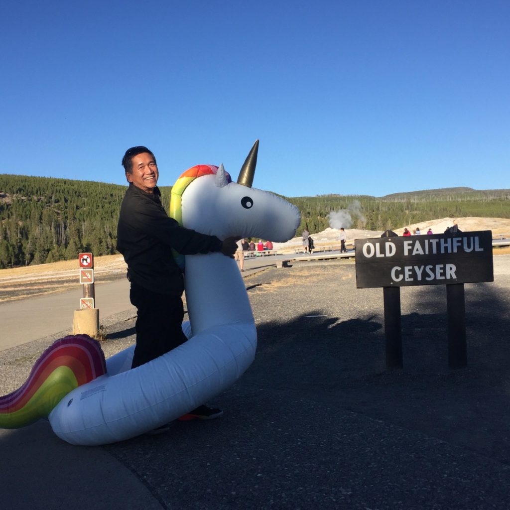 man with inflatable unicorn and Mount Rushmore 