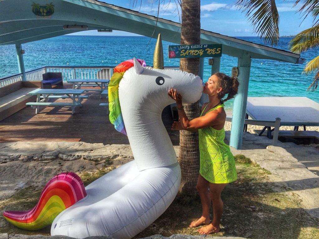 woman kissing inflatable unicorn in the Bahamas