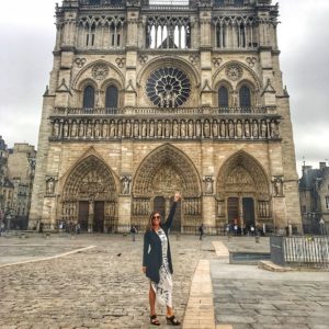 woman standing in front of Notre dame on a rainy day